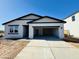 Modern, single-story home featuring a light stucco exterior, dark trim, a two-car garage, and concrete driveway at 46819 W Cansados Rd, Maricopa, AZ 85139