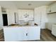 Bright, unfinished kitchen featuring white cabinets, a central island, and ample space for appliances at 46819 W Cansados Rd, Maricopa, AZ 85139