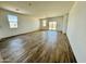 Large open-concept living room with beautiful wood-look flooring, bright white walls, and access to the backyard at 46819 W Cansados Rd, Maricopa, AZ 85139