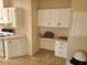 Well-lit kitchen featuring bright cabinets, tile flooring, a work desk, and additional storage at 5402 E Mckellips Rd # 103, Mesa, AZ 85215