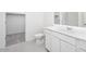 Bright bathroom featuring a single sink vanity, toilet, and a shower over tub with glass doors at 5761 E Iris Dr, Florence, AZ 85132