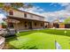 Lush backyard boasts a putting green, a porch swing, flowering plants, and a covered patio area at 5910 W Blue Sky Dr, Phoenix, AZ 85083