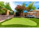 Beautiful backyard featuring putting green, lush landscaping, porch swing, and beautiful trees; ideal for relaxation at 5910 W Blue Sky Dr, Phoenix, AZ 85083