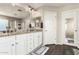Bathroom featuring double sinks with granite counters and white cabinets, plus a view to the shower at 5910 W Blue Sky Dr, Phoenix, AZ 85083