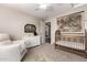 Bedroom with wood crib, changing table, dresser, carpet, and white armchair at 5910 W Blue Sky Dr, Phoenix, AZ 85083