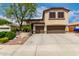 Two story home featuring a three car garage, desert landscaping and a mature shade tree at 5910 W Blue Sky Dr, Phoenix, AZ 85083