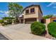Exterior view of a two story home with a three car garage, desert landscaping and mature trees at 5910 W Blue Sky Dr, Phoenix, AZ 85083