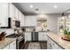 A modern kitchen features granite countertops, stainless steel appliances, white cabinets and a decorative rug at 5910 W Blue Sky Dr, Phoenix, AZ 85083