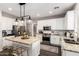 A modern kitchen features stainless appliances, granite countertops, and pendant lighting over a central island at 5910 W Blue Sky Dr, Phoenix, AZ 85083