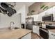 Well-equipped kitchen features stainless steel appliances, white cabinets, tan countertops, and hanging pot rack at 654 W Fremont Dr, Tempe, AZ 85282