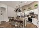 The kitchen has a tan countertops, stainless steel appliances, a hanging pot rack, and 3 bar stools at the island at 654 W Fremont Dr, Tempe, AZ 85282
