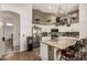 Bright kitchen featuring stainless steel appliances, white cabinets, tan countertops, hanging pot rack, and breakfast bar at 654 W Fremont Dr, Tempe, AZ 85282