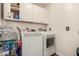 A practical laundry room featuring modern appliances, white cabinets, and ample storage at 654 W Fremont Dr, Tempe, AZ 85282