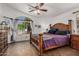 Spacious main bedroom featuring a statement bed, ceiling fan, and view of the back yard through large window at 654 W Fremont Dr, Tempe, AZ 85282