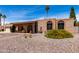 Single-story brick home featuring arched entryway, desert landscaping, and a two-car garage at 6622 E Voltaire Ave, Scottsdale, AZ 85254