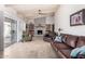 Spacious living room with travertine floors, beamed ceiling, brick fireplace, and access to outdoor space at 6622 E Voltaire Ave, Scottsdale, AZ 85254