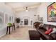Bright living room featuring beamed ceiling, large windows, travertine floors, and leather furniture at 6622 E Voltaire Ave, Scottsdale, AZ 85254