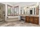 Luxurious bathroom featuring a soaking tub, decorative tile and wooden cabinetry at 7018 E Ingram St, Mesa, AZ 85207