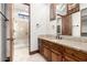 Bathroom with a granite vanity, a crystal chandelier, and an enclosed shower with travertine style tile at 7018 E Ingram St, Mesa, AZ 85207