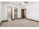 A bright bedroom features a ceiling fan, neutral carpet, with doorways to the bathroom and walk-in closet at 7018 E Ingram St, Mesa, AZ 85207