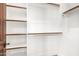 An organized walk-in closet with white shelving and chrome closet rods for optimal storage solutions at 7018 E Ingram St, Mesa, AZ 85207