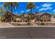 Stunning home featuring desert landscaping, mature palm trees, and a beautiful stone and stucco facade at 7018 E Ingram St, Mesa, AZ 85207