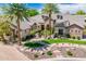 Expansive estate showcasing a meticulously landscaped front yard, mature palm trees, and an elegant stone and stucco facade at 7018 E Ingram St, Mesa, AZ 85207