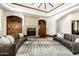 Elegant living room featuring a stone fireplace, hardwood floors, and stylish grey leather sofas at 7018 E Ingram St, Mesa, AZ 85207
