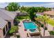 Aerial view of backyard featuring swimming pool, spa, covered patio with lounge furniture, and mature trees at 7018 E Ingram St, Mesa, AZ 85207