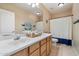 Bathroom featuring dual sinks, wood cabinets, and neutral colored walls at 7438 E Glenn Moore Rd, Scottsdale, AZ 85255