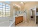 Bright bathroom featuring a soaking tub, glass-enclosed shower, and neutral tile flooring at 7438 E Glenn Moore Rd, Scottsdale, AZ 85255