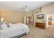 Bright main bedroom with TV, plush carpet, and open doorway to en-suite bathroom at 7438 E Glenn Moore Rd, Scottsdale, AZ 85255