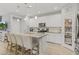 White kitchen with stainless steel appliances, an island with bar seating, pantry, and wood-style flooring at 7732 S 23Rd St, Phoenix, AZ 85042