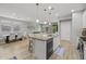 Open concept kitchen with a center island, bar stool seating, and wood floors; dining area and living area visible at 7732 S 23Rd St, Phoenix, AZ 85042