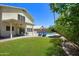 Backyard featuring a pool, covered patio, and desert landscaping with lush green grass at 8228 S Stephanie Ln, Tempe, AZ 85284