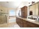Bathroom featuring a double sink vanity, a large mirror, and a shower-bathtub combination with tiled walls at 8228 S Stephanie Ln, Tempe, AZ 85284
