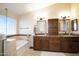 Bright bathroom featuring double sinks with granite countertops, a bathtub and a glass door shower at 8228 S Stephanie Ln, Tempe, AZ 85284