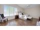 Bright bedroom featuring a large window, ceiling fan, hardwood floors, and a comfortable cushioned chair at 8228 S Stephanie Ln, Tempe, AZ 85284