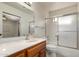 Bright bathroom featuring a shower with glass doors, wooden vanity, and a large mirror at 8255 E Kiva Ave # 420, Mesa, AZ 85209