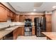 Well-lit kitchen featuring stainless steel appliances, neutral countertops, wooden cabinets, and tile backsplash at 8255 E Kiva Ave # 420, Mesa, AZ 85209