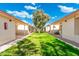 Exterior shot of backyard featuring a lush green lawn and pathways between buildings showcasing the landscape at 8255 E Kiva Ave # 422, Mesa, AZ 85209