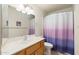 Well-lit bathroom featuring a single sink vanity with a large mirror and a shower with a decorative curtain at 8255 E Kiva Ave # 422, Mesa, AZ 85209