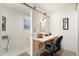 Neutral bedroom with desk, sconce light, and view into hallway with tiled floors at 8255 E Kiva Ave # 422, Mesa, AZ 85209