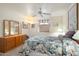 Bedroom with ceiling fan, window with patterned valance, dresser, and a comfortable bed at 8255 E Kiva Ave # 422, Mesa, AZ 85209
