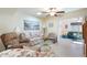 Cozy living room with tile floors, ceiling fan, and comfortable seating area with floral sofa and glass coffee table at 8255 E Kiva Ave # 422, Mesa, AZ 85209