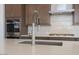 Kitchen island with stainless sink, modern faucet, and stainless appliances at 852 W Golden Ore Pass, Apache Junction, AZ 85120