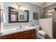Bathroom features a wood vanity, framed mirror and tiled walk-in shower at 9243 W Kimberly Way, Peoria, AZ 85382