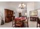Traditional dining room with wood table, chairs, hutch, and decorative chandelier, flowing into the living room at 9243 W Kimberly Way, Peoria, AZ 85382