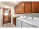 Laundry room with washer, dryer, utility sink, and wooden cabinets at 9243 W Kimberly Way, Peoria, AZ 85382