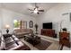 Vaulted living room with tile floors, tan couches, and a ceiling fan at 9243 W Kimberly Way, Peoria, AZ 85382